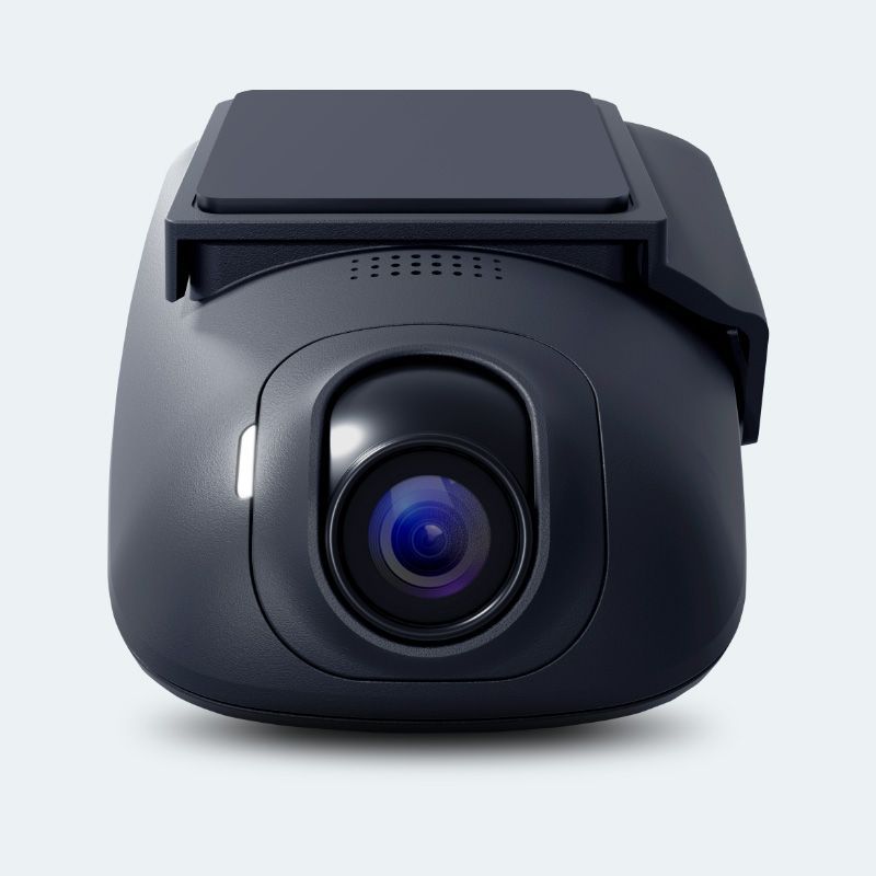 A black camera is sitting on a white surface.
