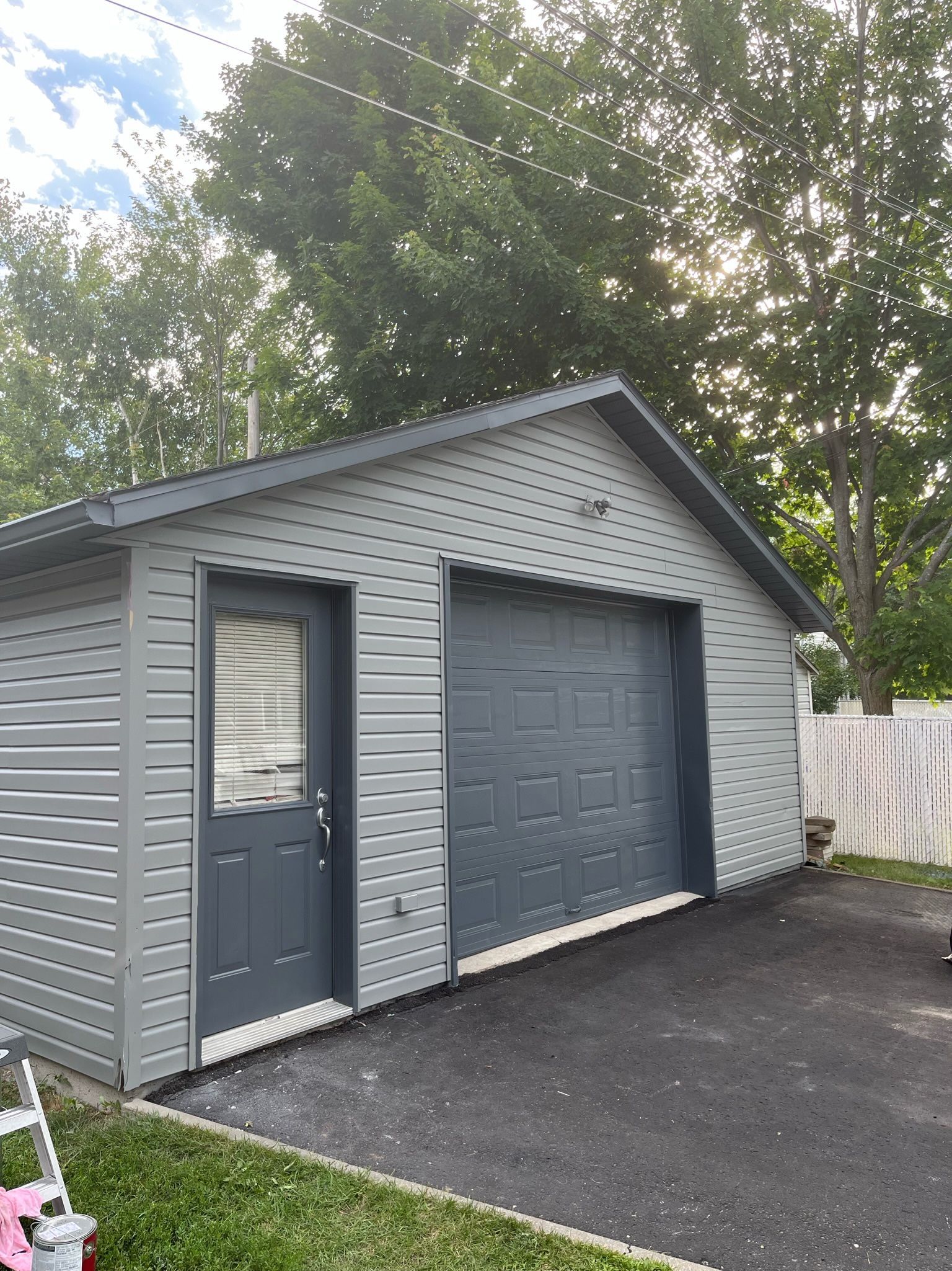 un garage avec deux portes de garage et une échelle devant .