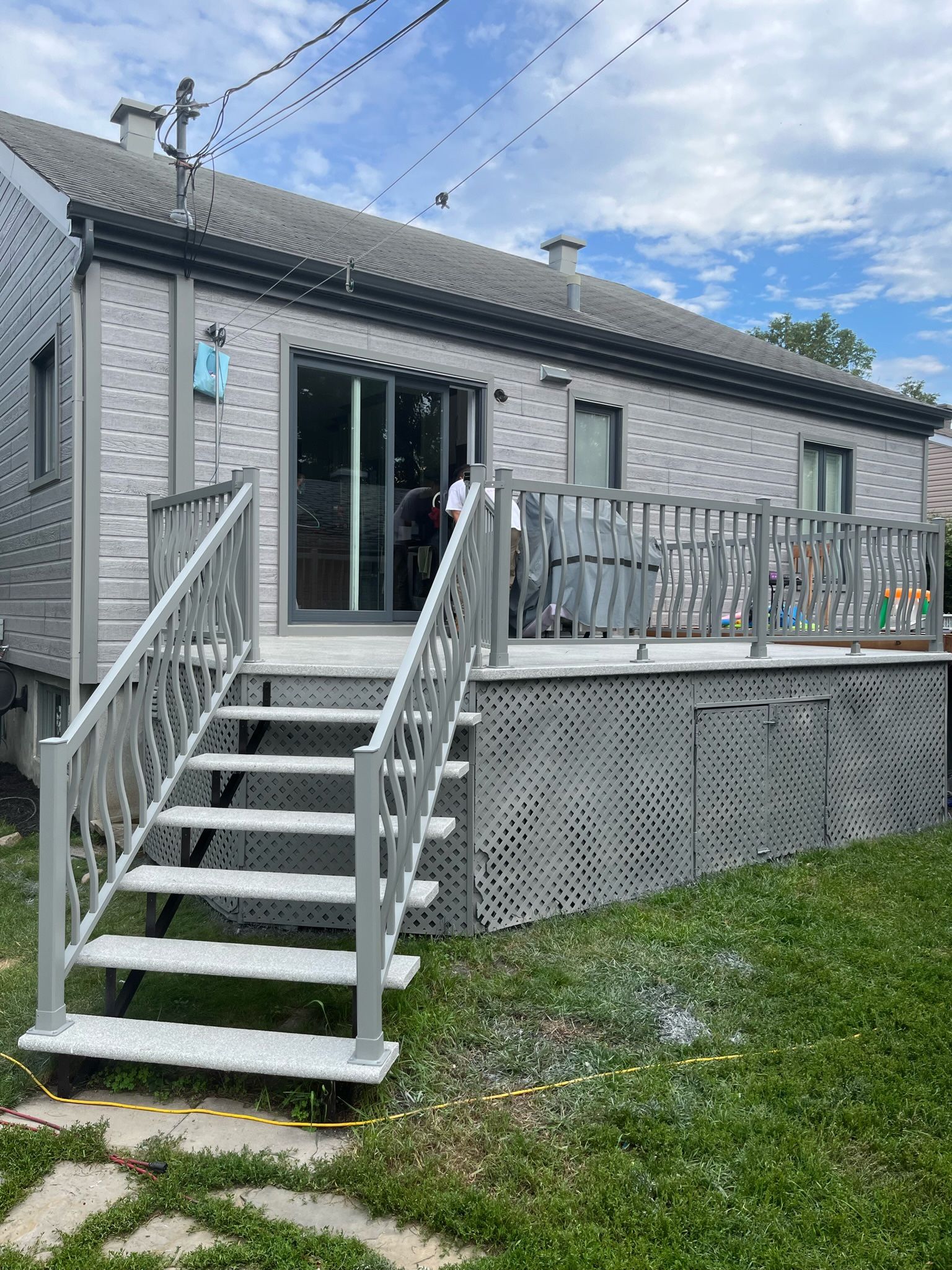 une maison avec une terrasse et des escaliers qui y mènent.