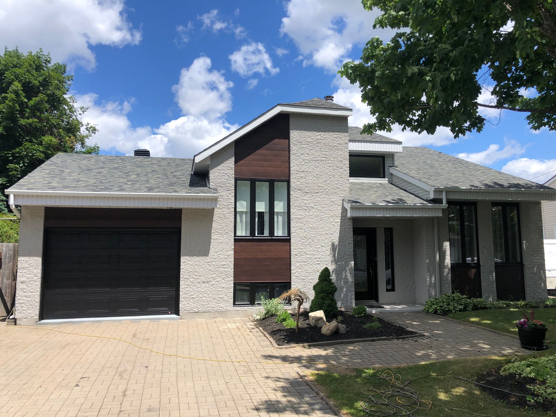 A large house with a gray roof and a black garage door