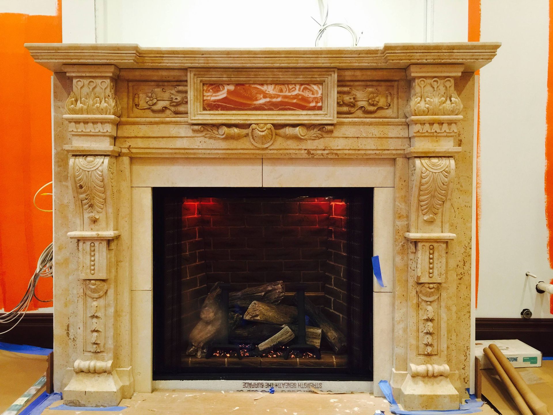 A fireplace with a brick mantle is sitting on a wooden floor.