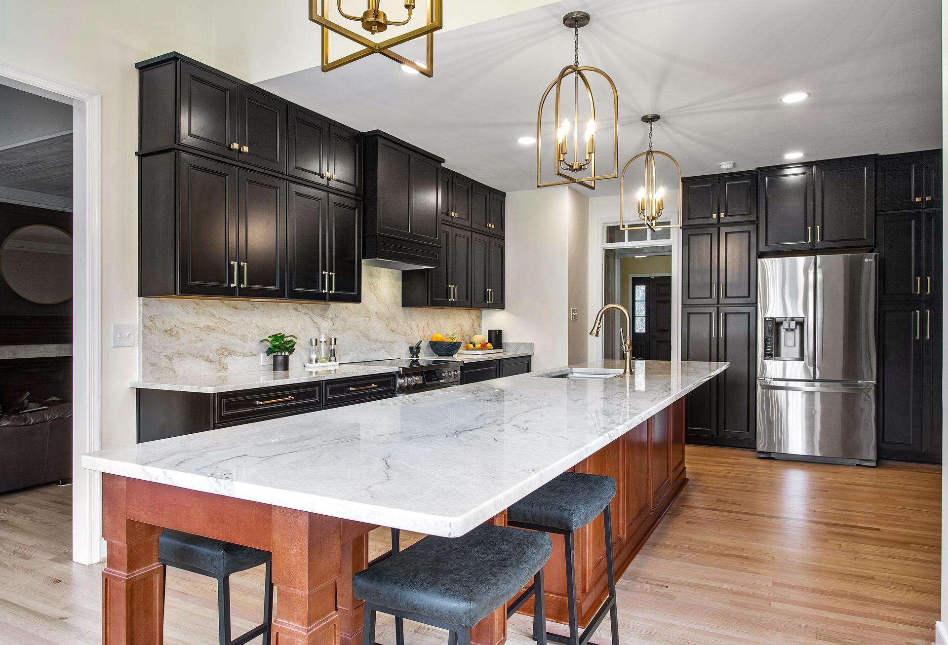 Kitchen Remodeler in RVA: A kitchen with black cabinets, white counter tops, stainless steel appliances and large island.