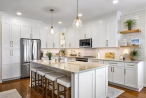 Kitchen Remodeling in RVA: A kitchen with white cabinets, granite counter tops, stainless steel appliances and a large island