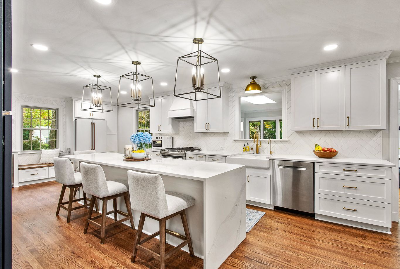 Kitchen Remodeler: A kitchen with white cabinets and stainless steel appliances and a large island.