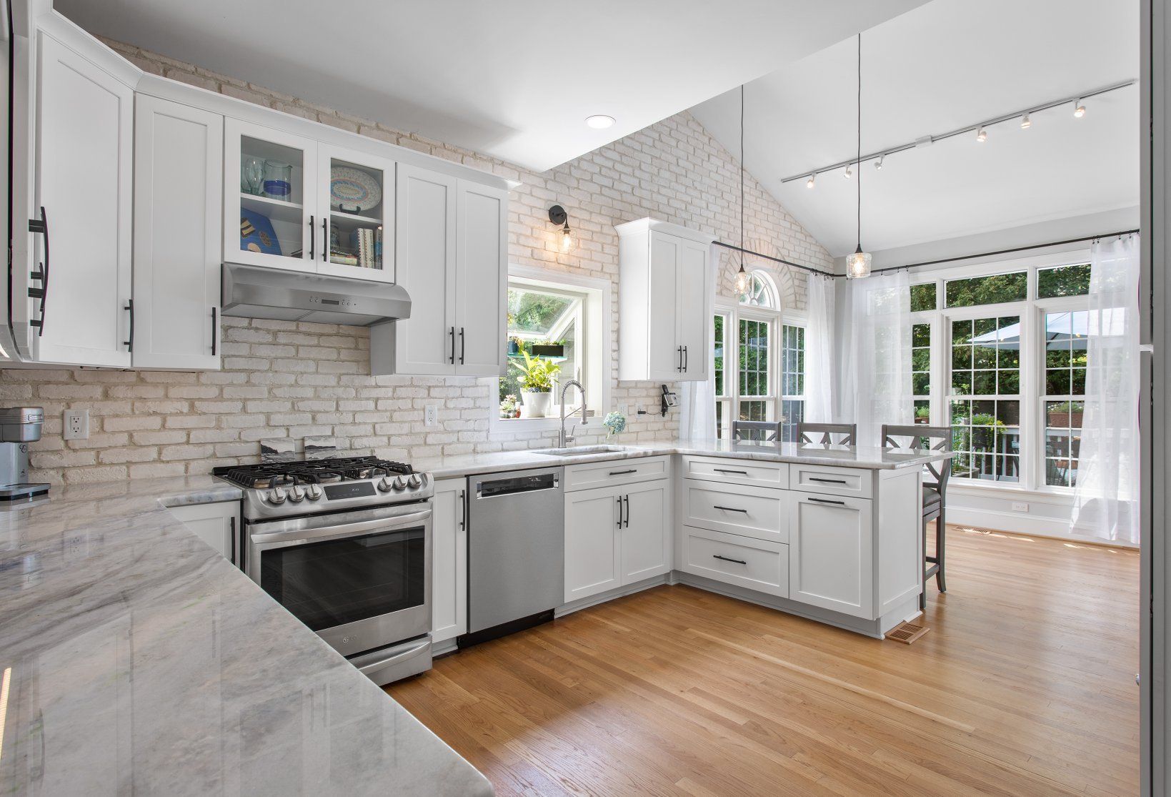 Kitchen Remodeler in Richmond, VA: A kitchen with white cabinets , stainless steel appliances , and hardwood floors.