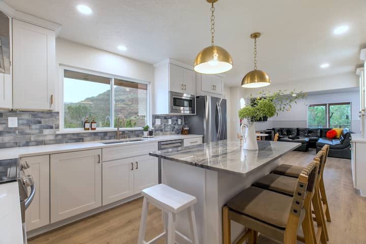 Modern kitchen with marble island, gold pendant lights, and stainless steel appliances