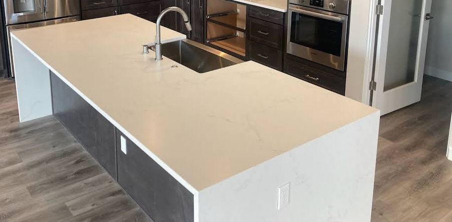 Modern kitchen with large white island, sink, and stainless steel appliances