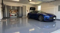 A home garage that has just had a fresh coat of epoxy applied to the floor with a nice car parked in the same garage.