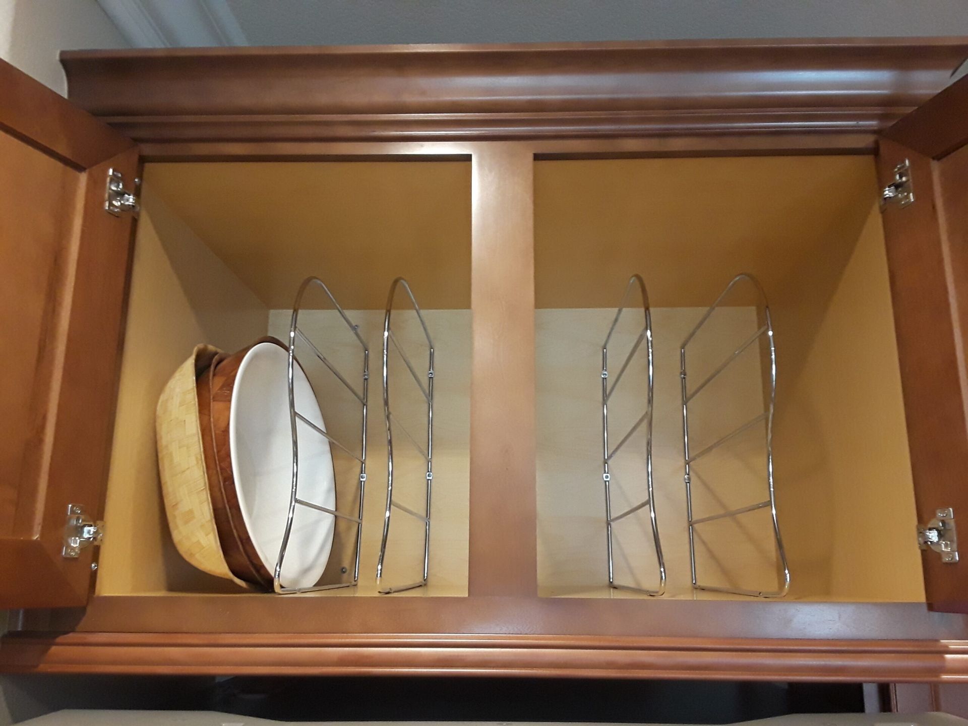 Two bowls are sitting inside of a cabinet with dividers