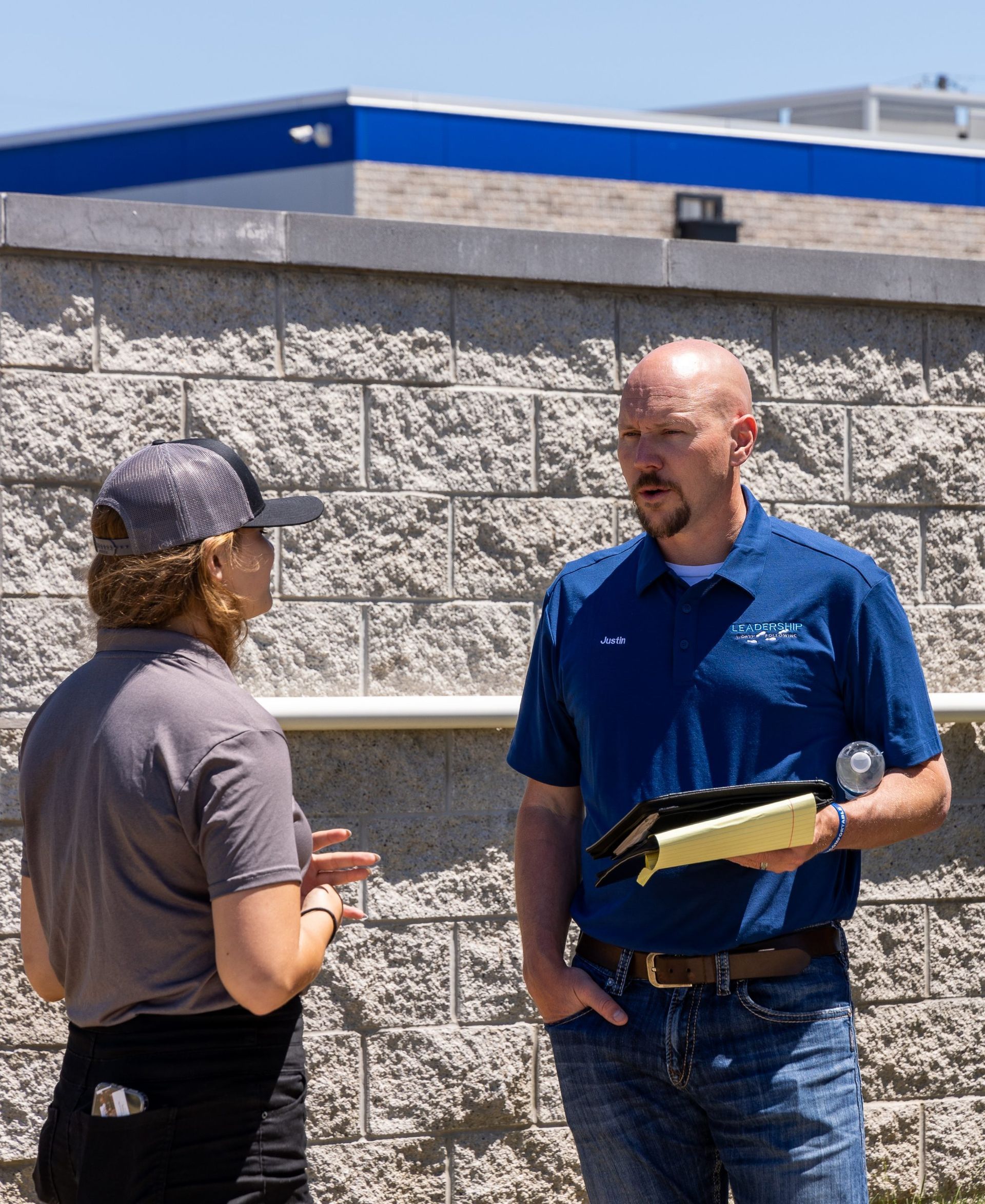 A man and a woman are talking in front of a brick wall