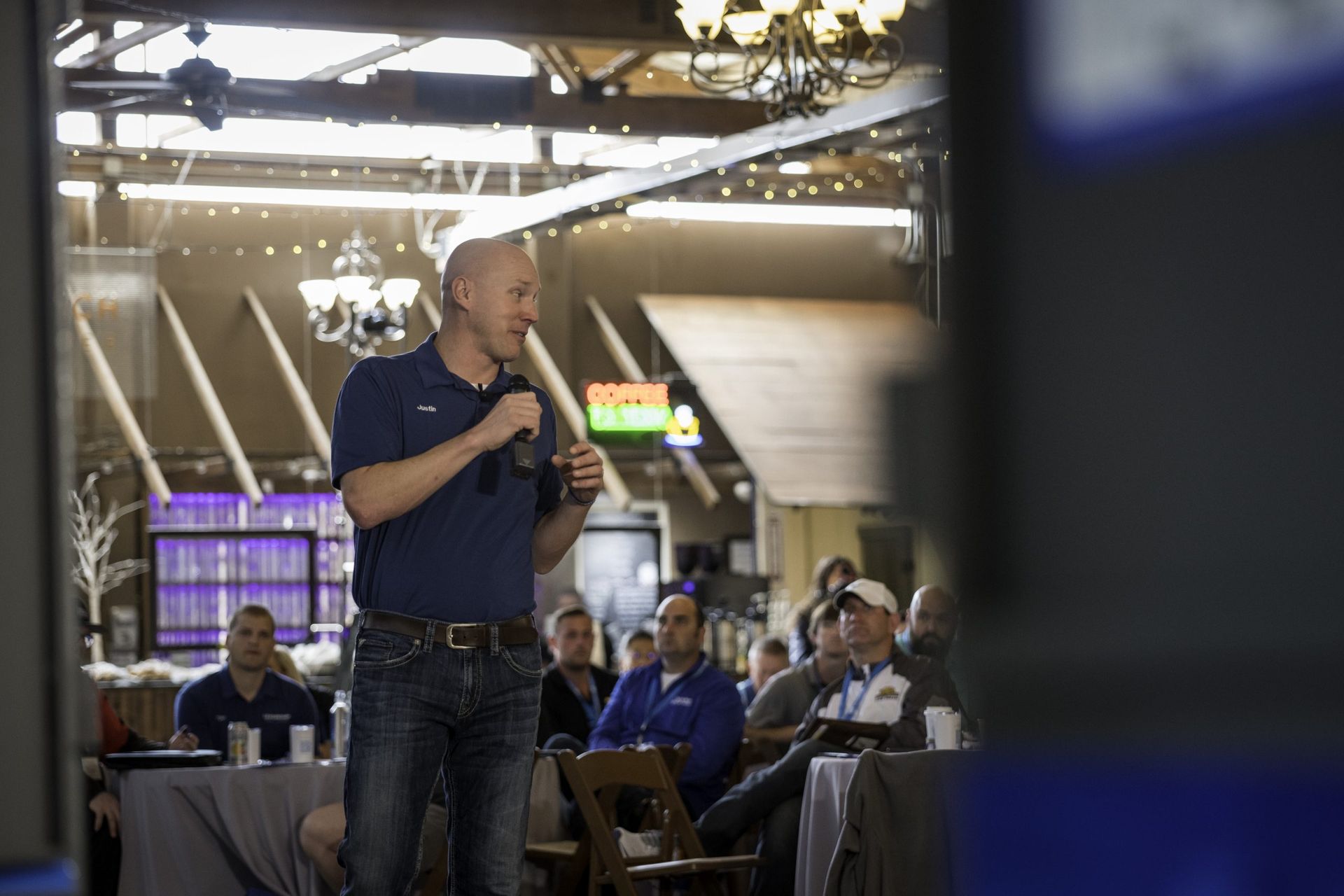 A man is giving a presentation to a group of people in a room.