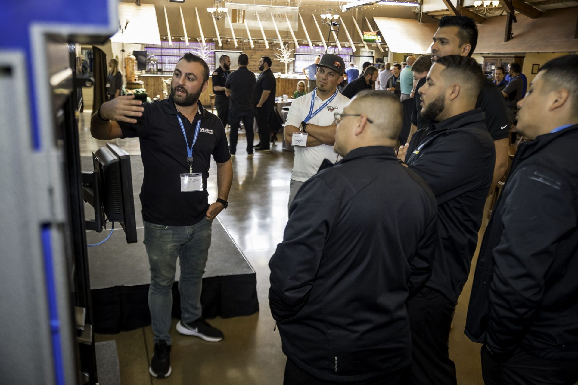 A man is talking to a group of men in a room.
