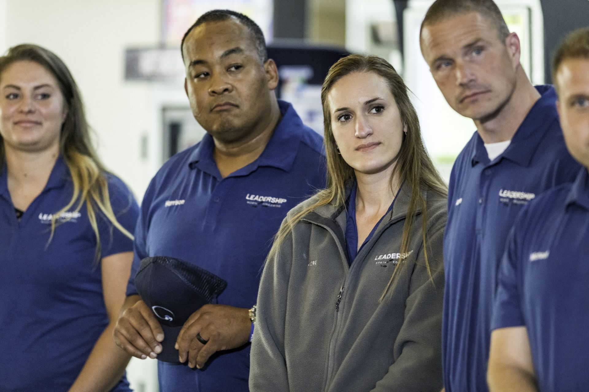 A group of people wearing blue shirts are standing next to each other.