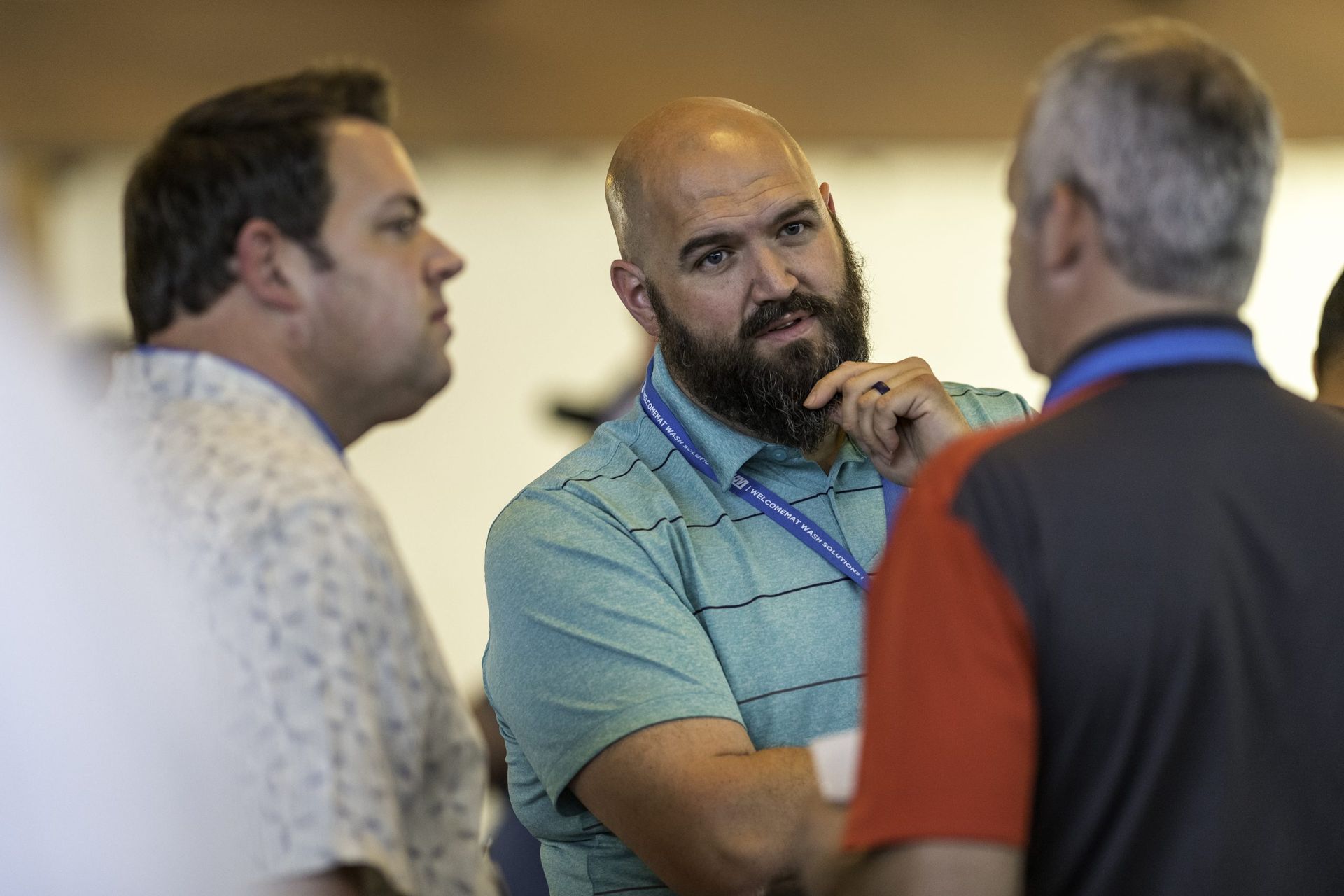 A group of men are standing around talking to each other.