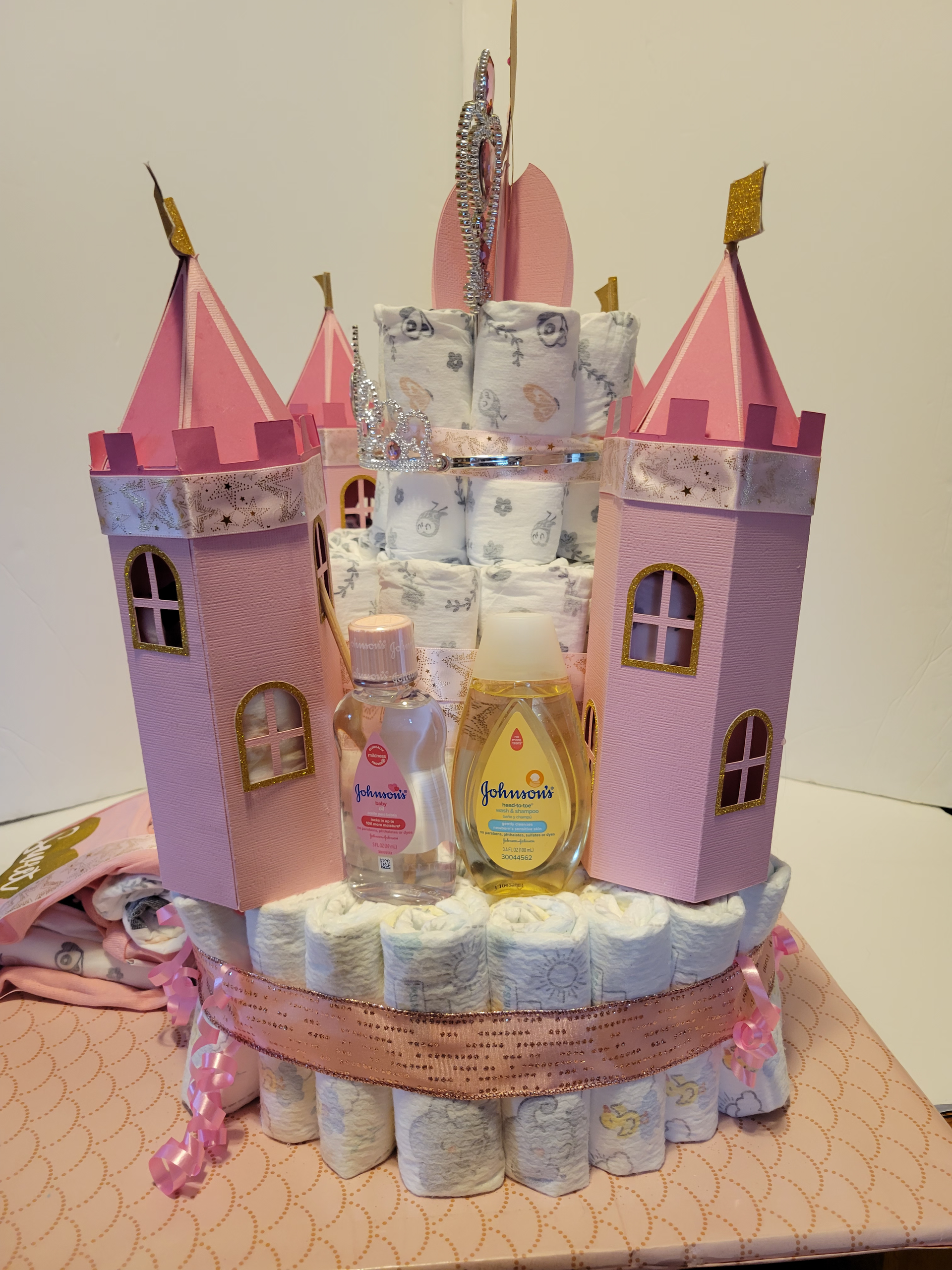 Pink castle-shaped cake with glittery decorations and a “Sweet” plaque on a tray