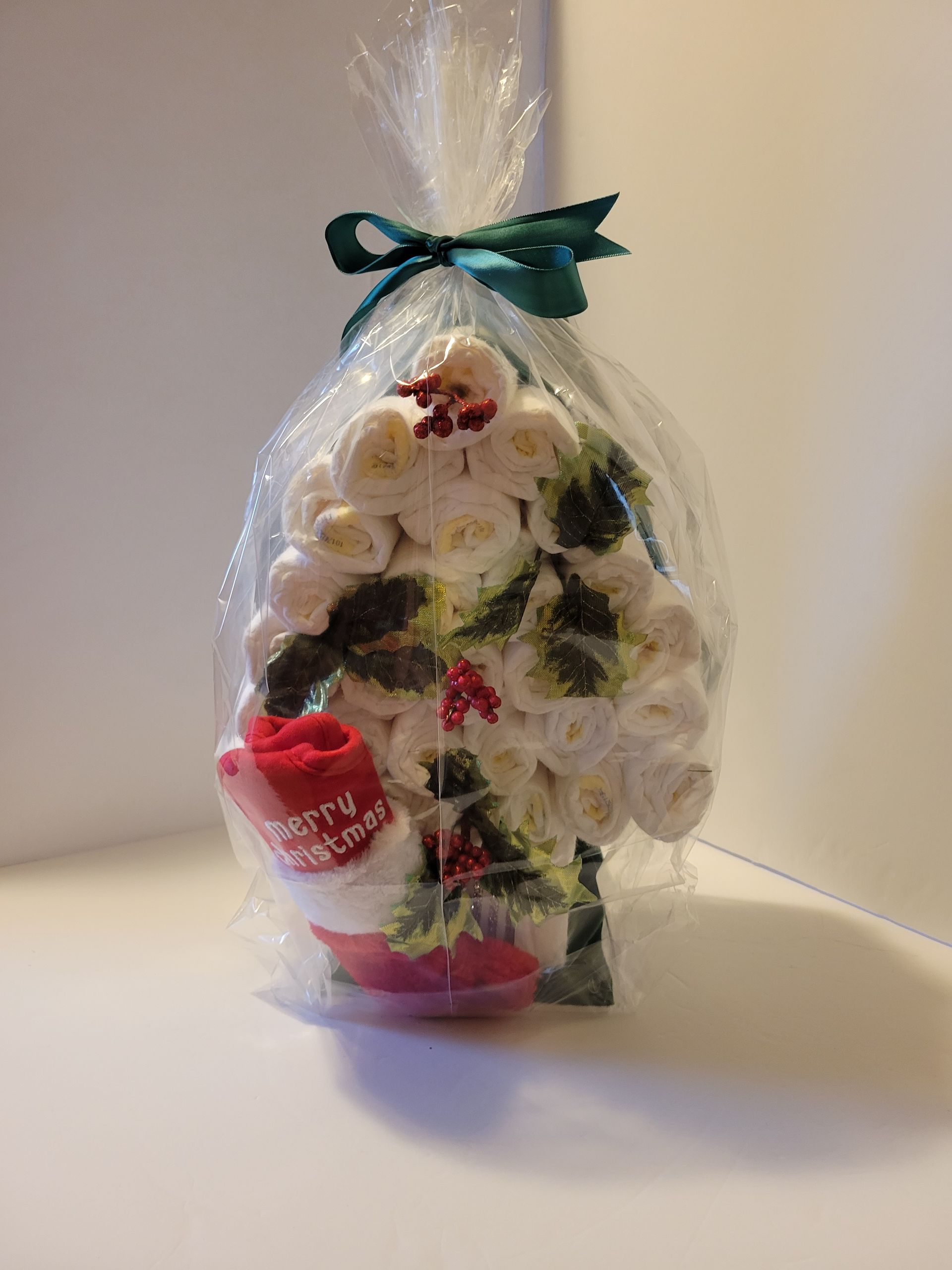 Christmas stocking made of rolled white flowers with red and green holiday accents on a black stand