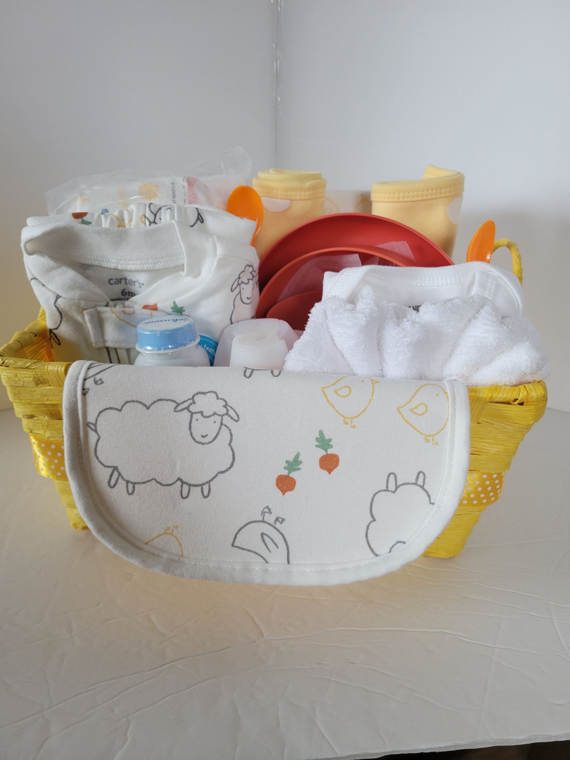Decorative basket holding tissues and baby care items, with a white front panel and yellow sides