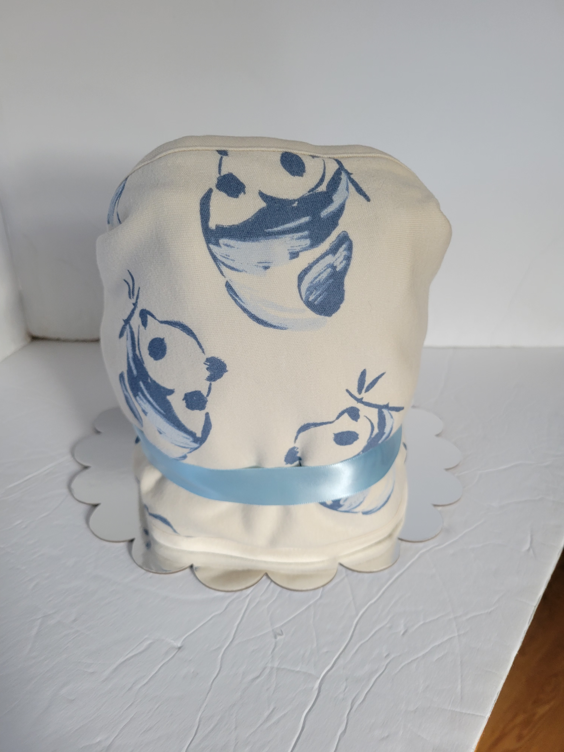 Blue miniature chair with matching tiny shoes and folded cloth on a white surface