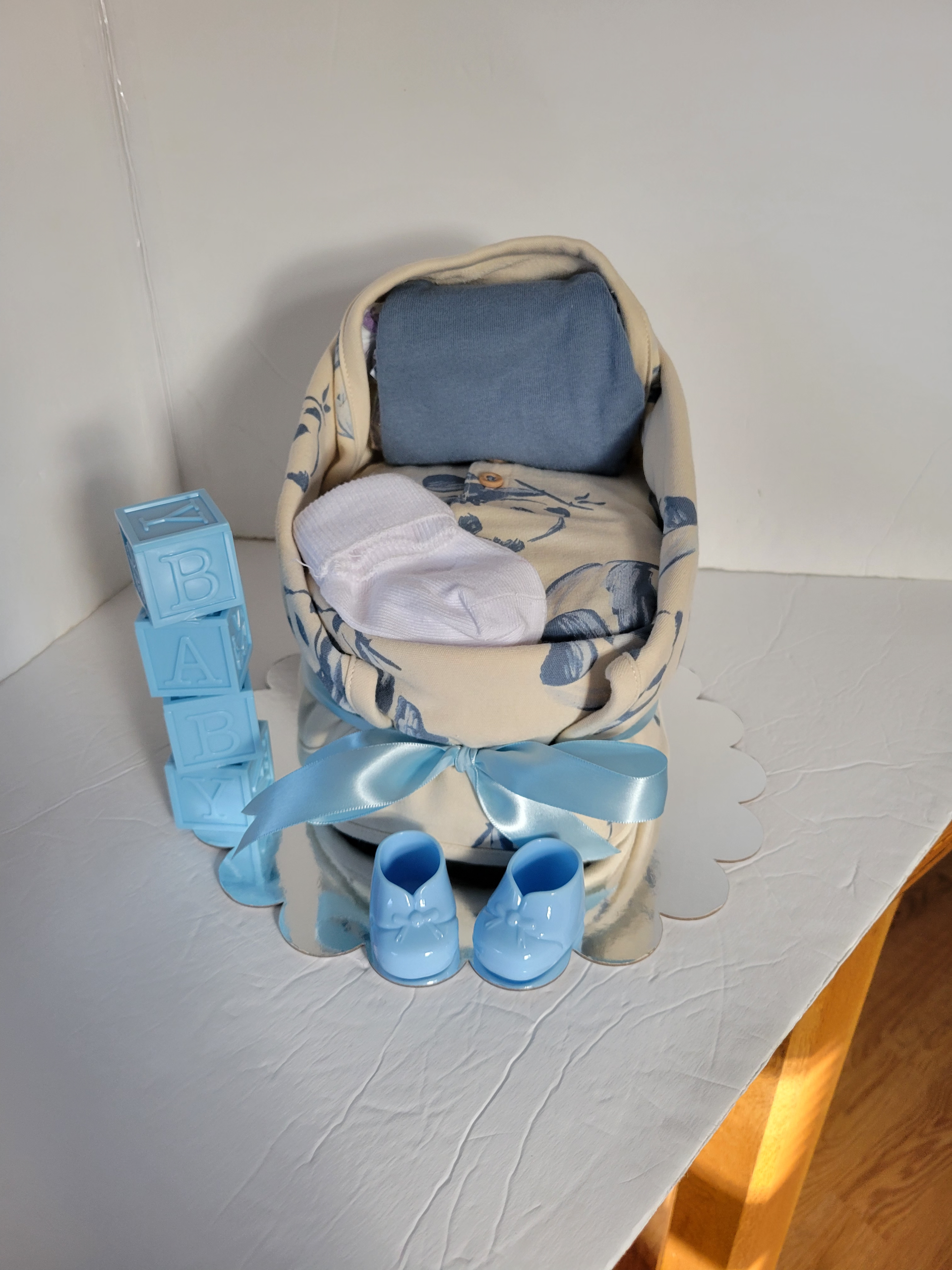 Blue miniature chair with matching tiny shoes and folded cloth on a white surface