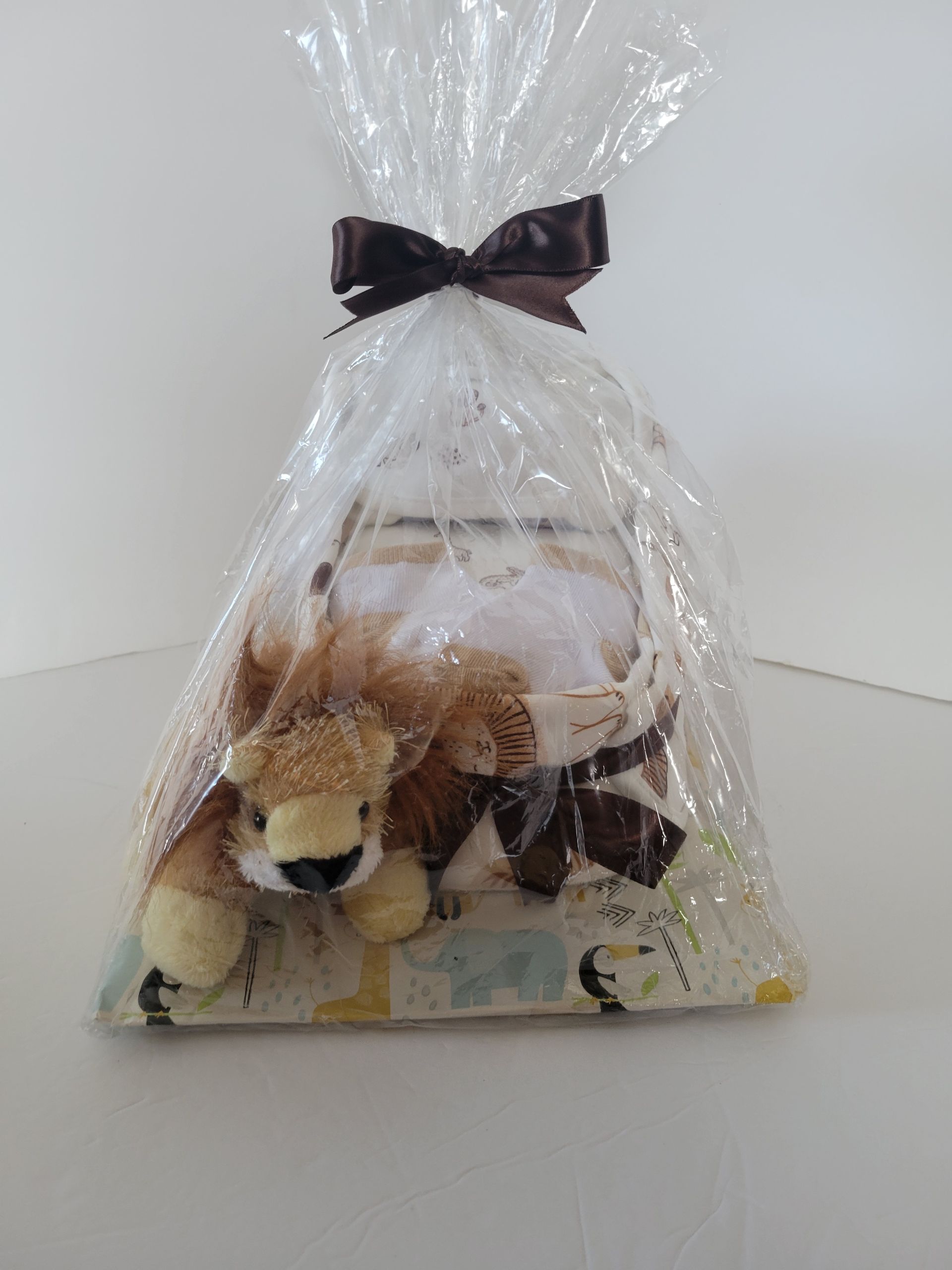 Gift basket with plush toys wrapped in clear cellophane and tied with a dark bow