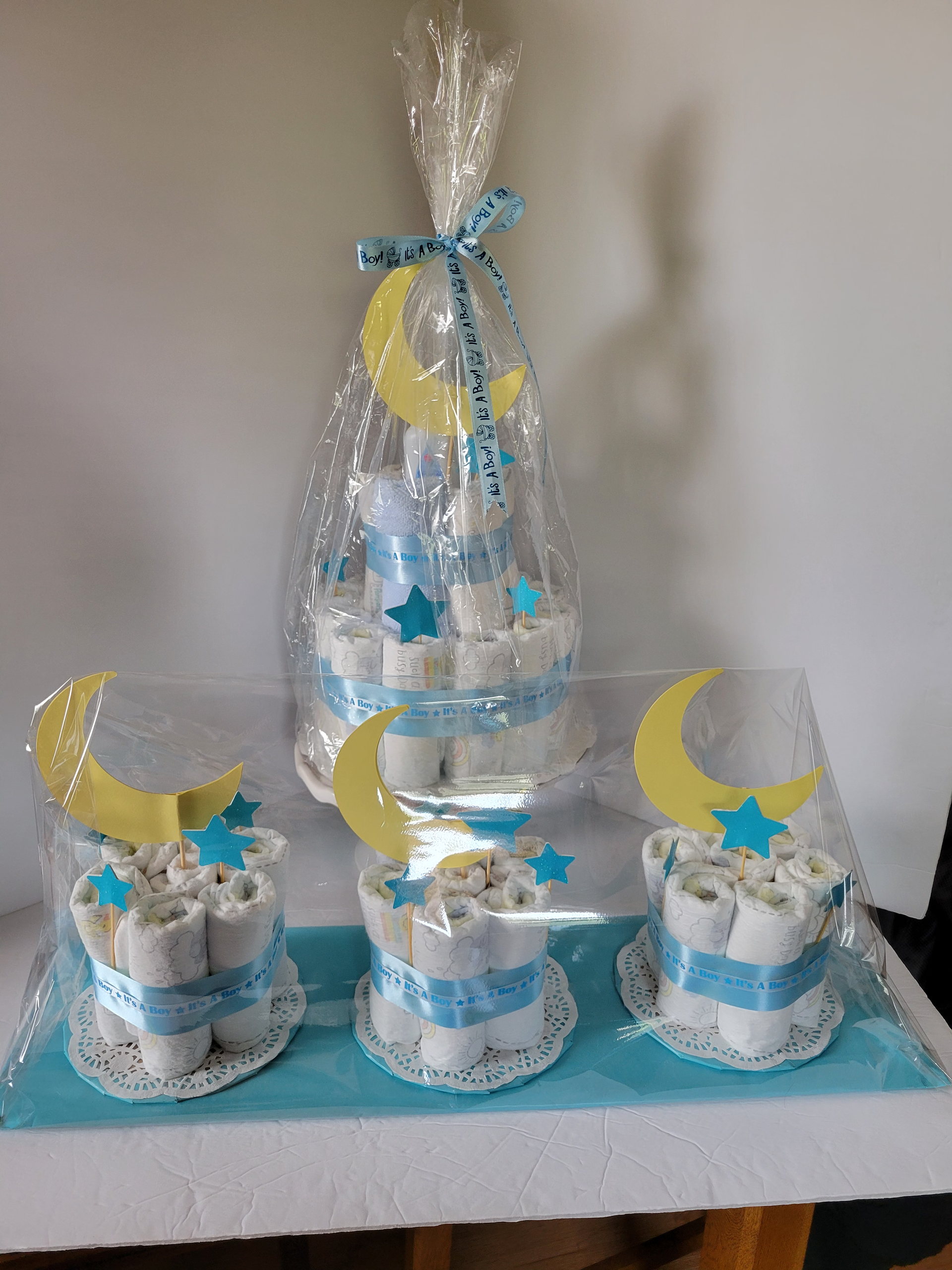 Five blue and white tiered cakes with yellow moons and blue stars on a table