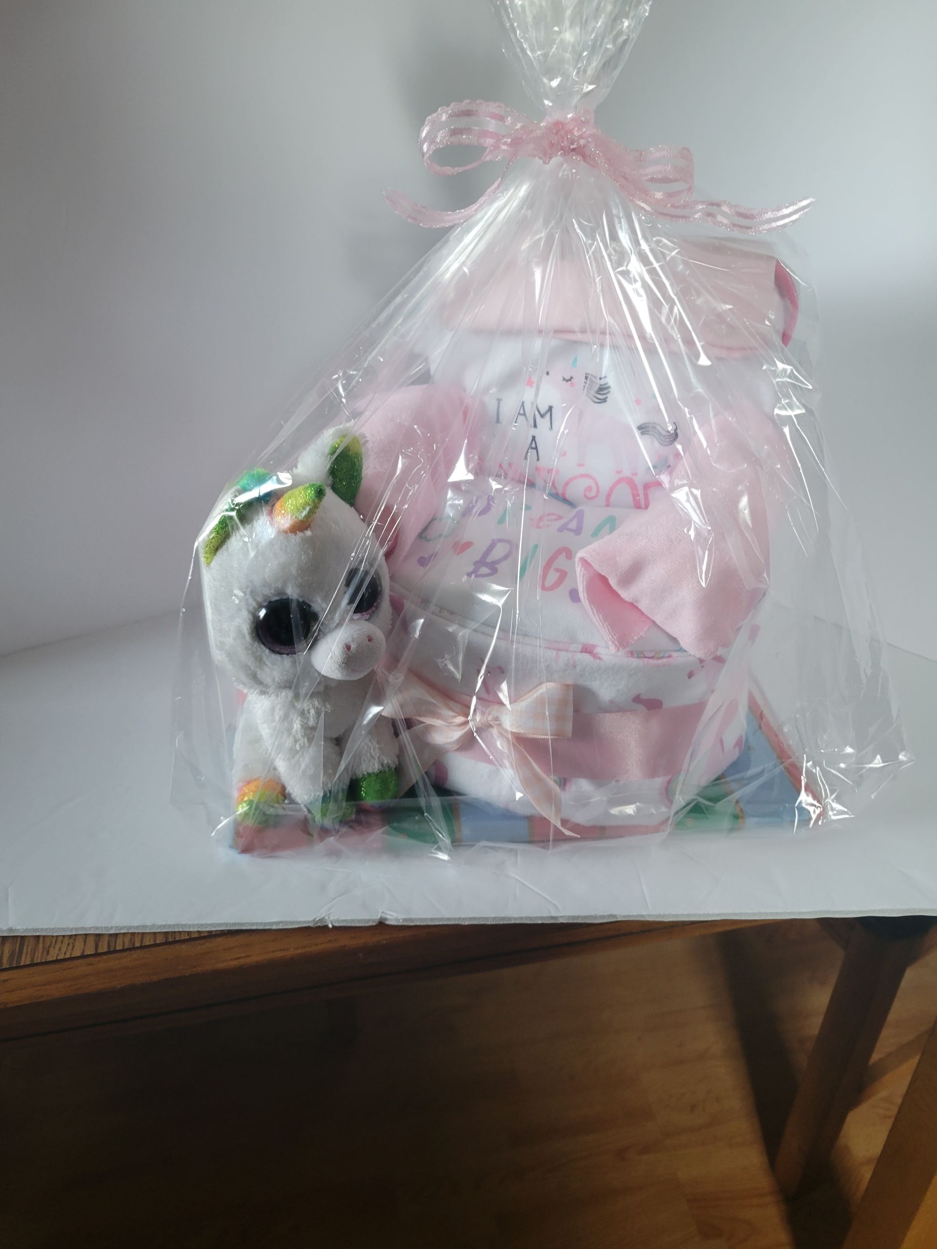 Pink-and-white handmade gift box with glittery unicorn figurine on a colorful base.
