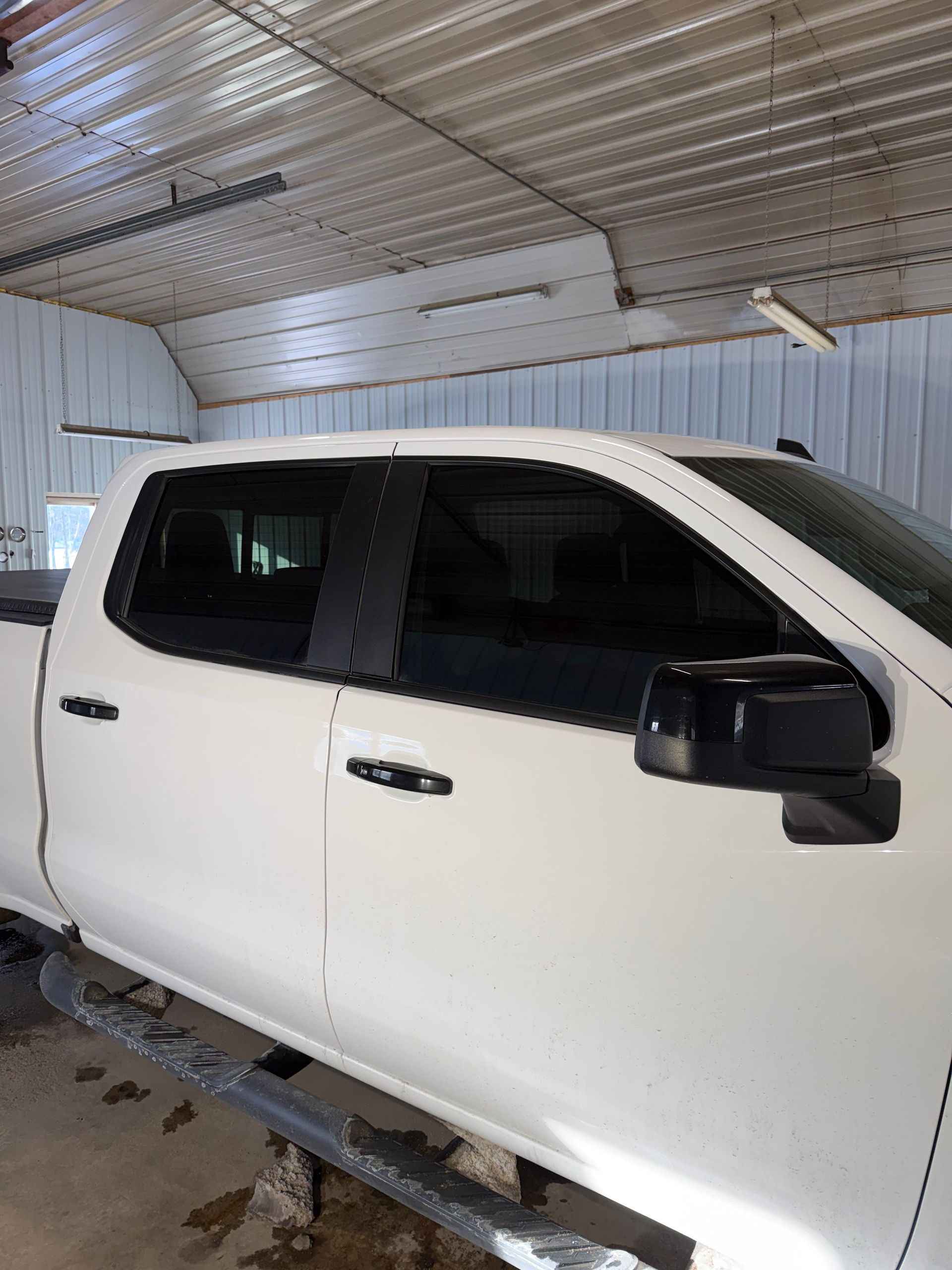 A man is polishing a car in a garage.