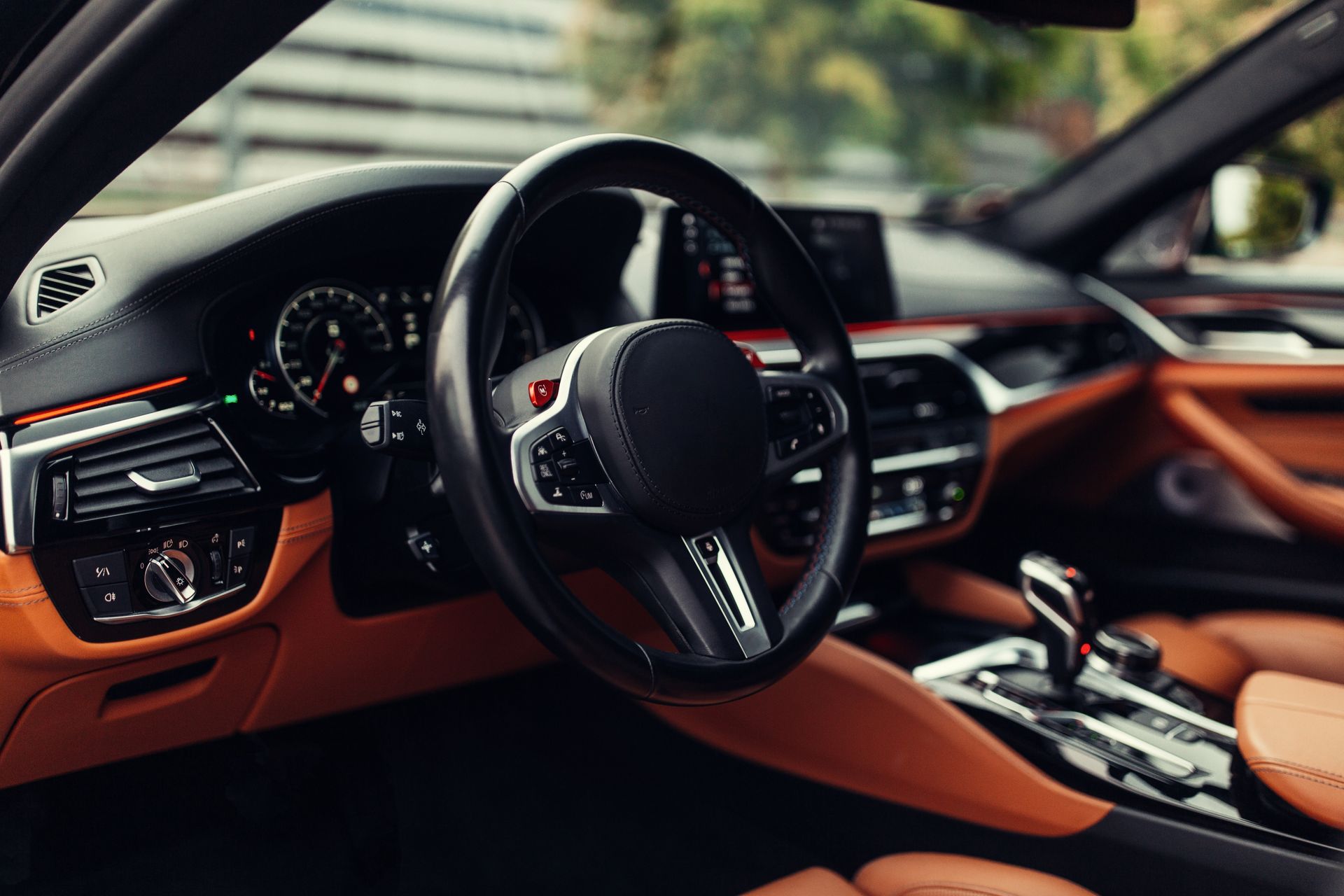 The interior of a car with brown leather seats and a steering wheel.