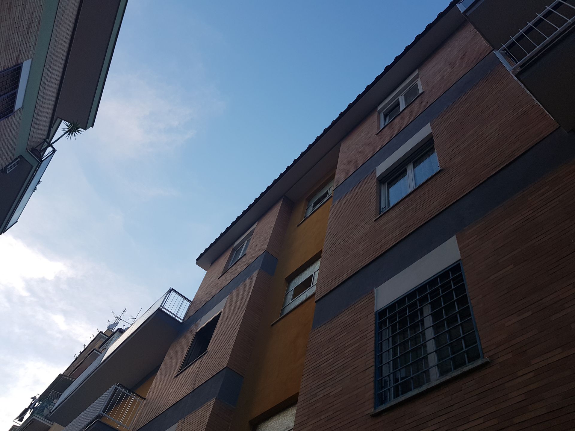 Vista dal basso di palazzi di mattoni contro un cielo azzurro.