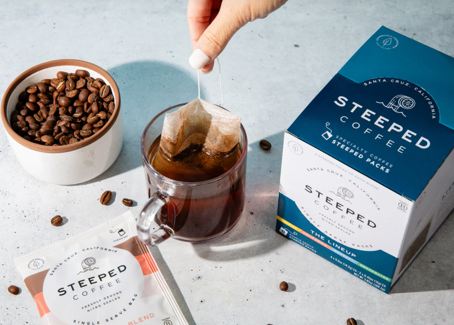 A person is adding sugar to a cup of steeped coffee.