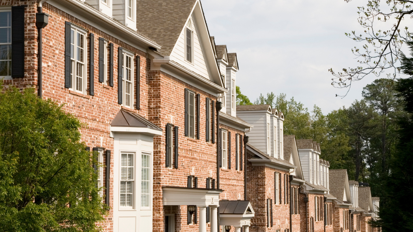 a row of brick houses with black shutters on the windows