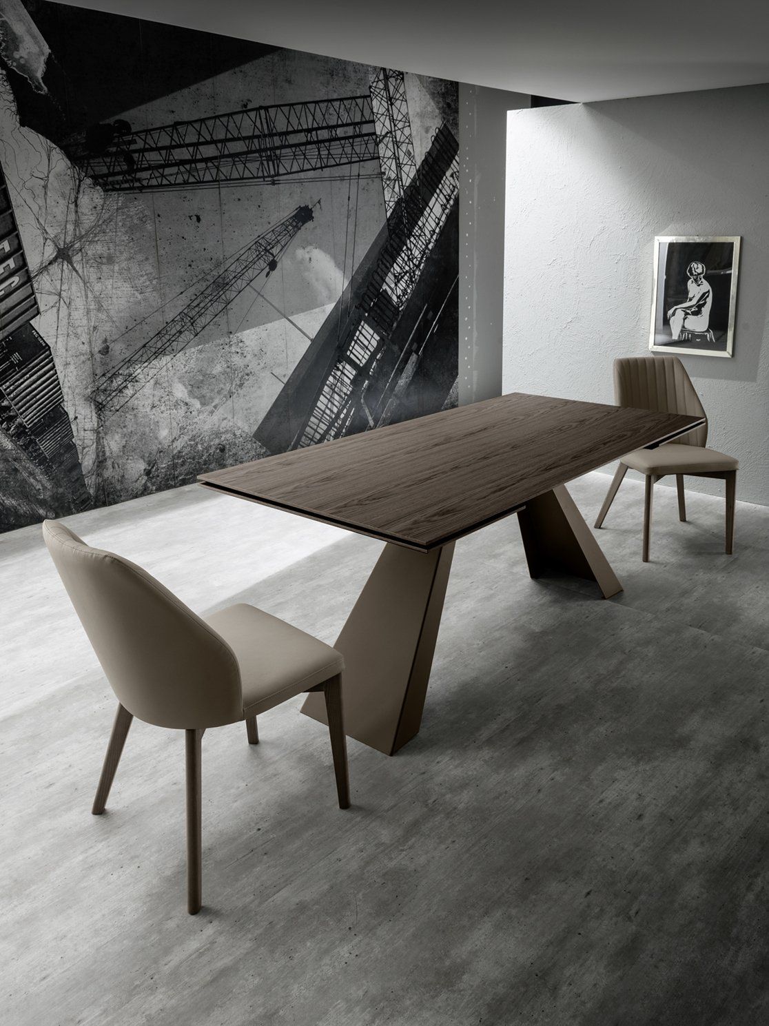 Sala da pranzo moderna con tavolo in legno scuro dalla base scultorea, due sedie neutre e un'opera d'arte astratta alla parete.