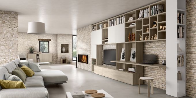 Soggiorno moderno caratterizzato da un grande divano angolare beige, una parete attrezzata in legno chiaro con ripiani e pareti in mattoni a vista.