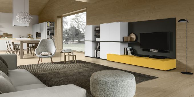Soggiorno moderno con consolle gialla, mobile TV a parete nero, pareti in legno chiaro e divano e poltrona grigi.