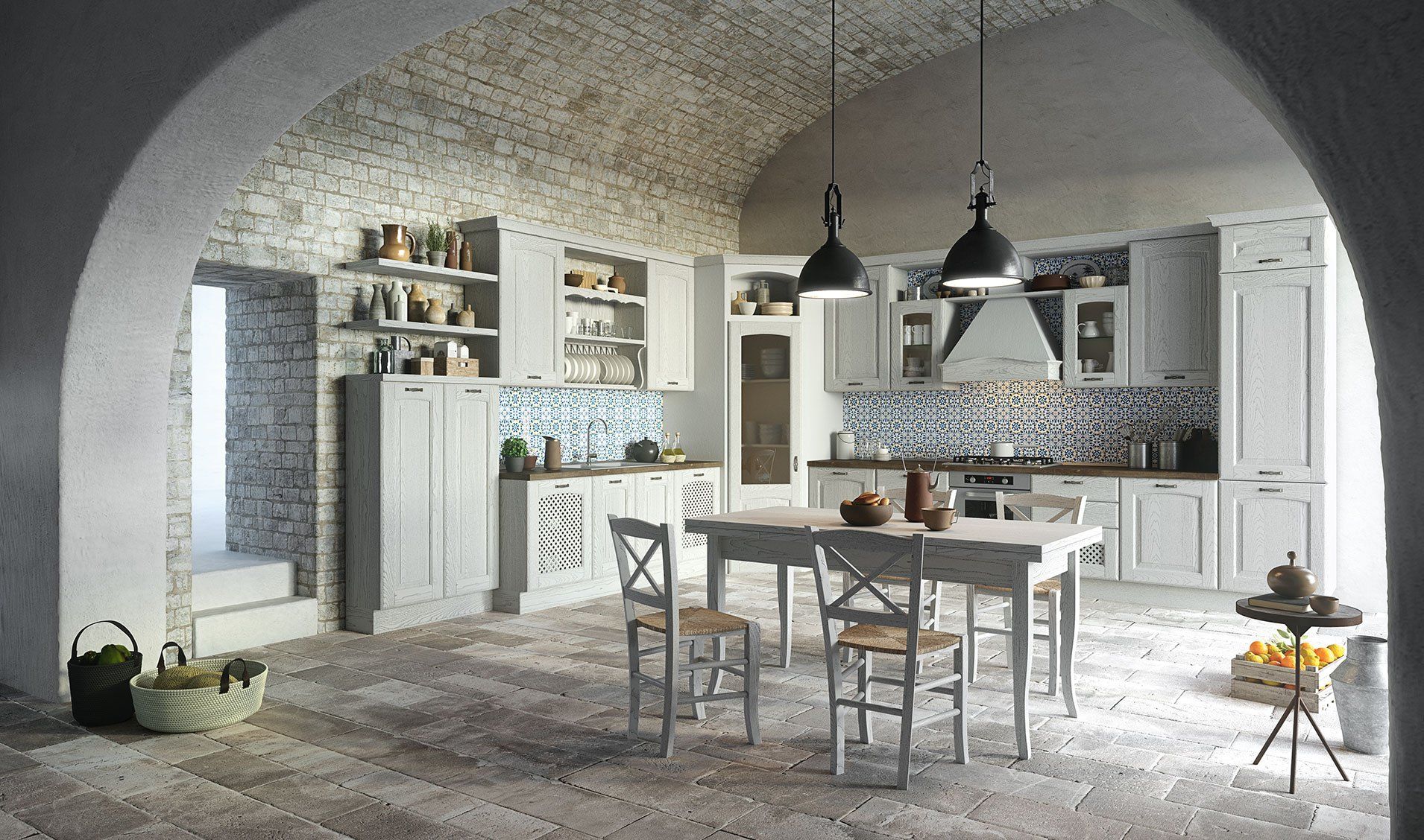 Cucina rustica con mobili bianchi, soffitto a volta in pietra, paraschizzi in piastrelle decorate e tavolo da pranzo in legno.