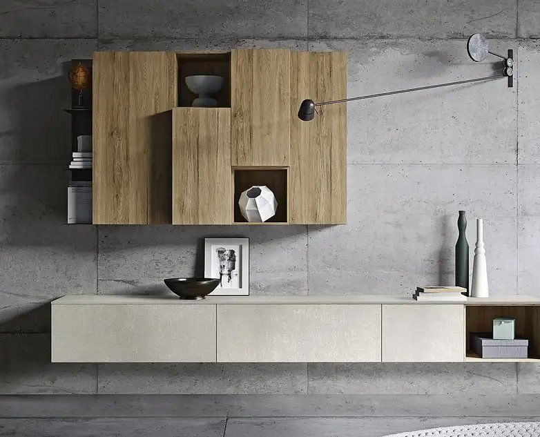 Mobili moderni e minimalisti a parete, con ante in legno chiaro e consolle color avorio, su uno sfondo di cemento grigio.