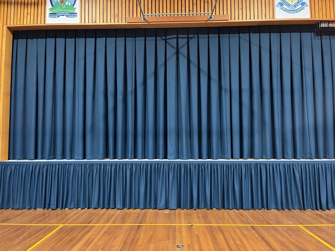 A Stage With Blue Curtains and a Wooden Floor — Newcastle Curtains And Blinds In Warners Bay, NSW