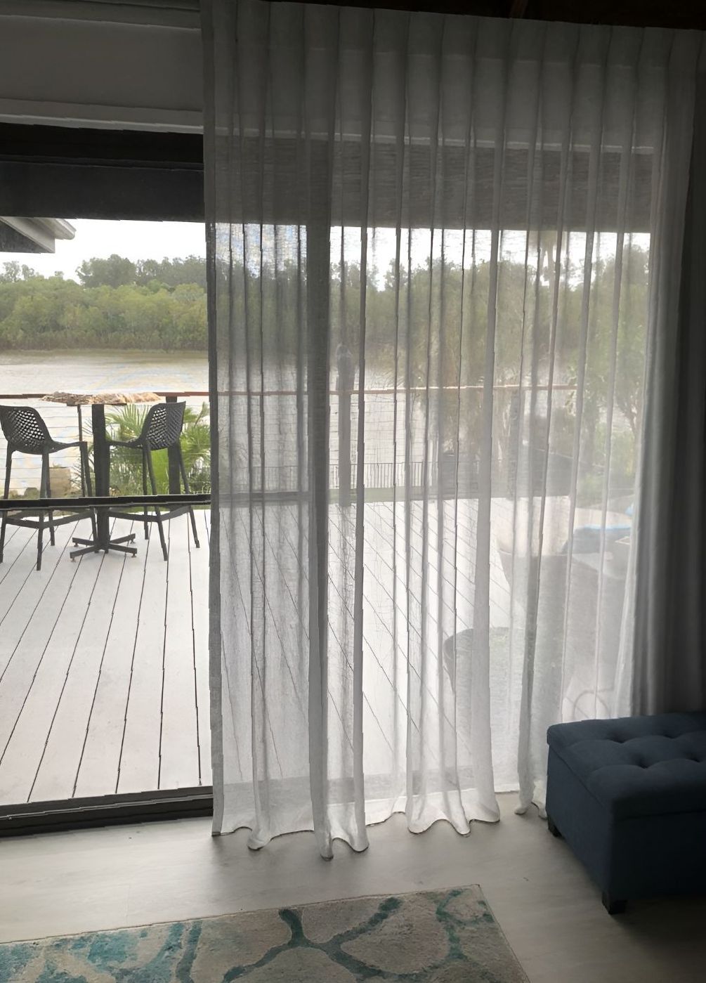 A Dining area looking out to lake with sheer curtains — Newcastle Curtains And Blinds In Warners Bay, NSW