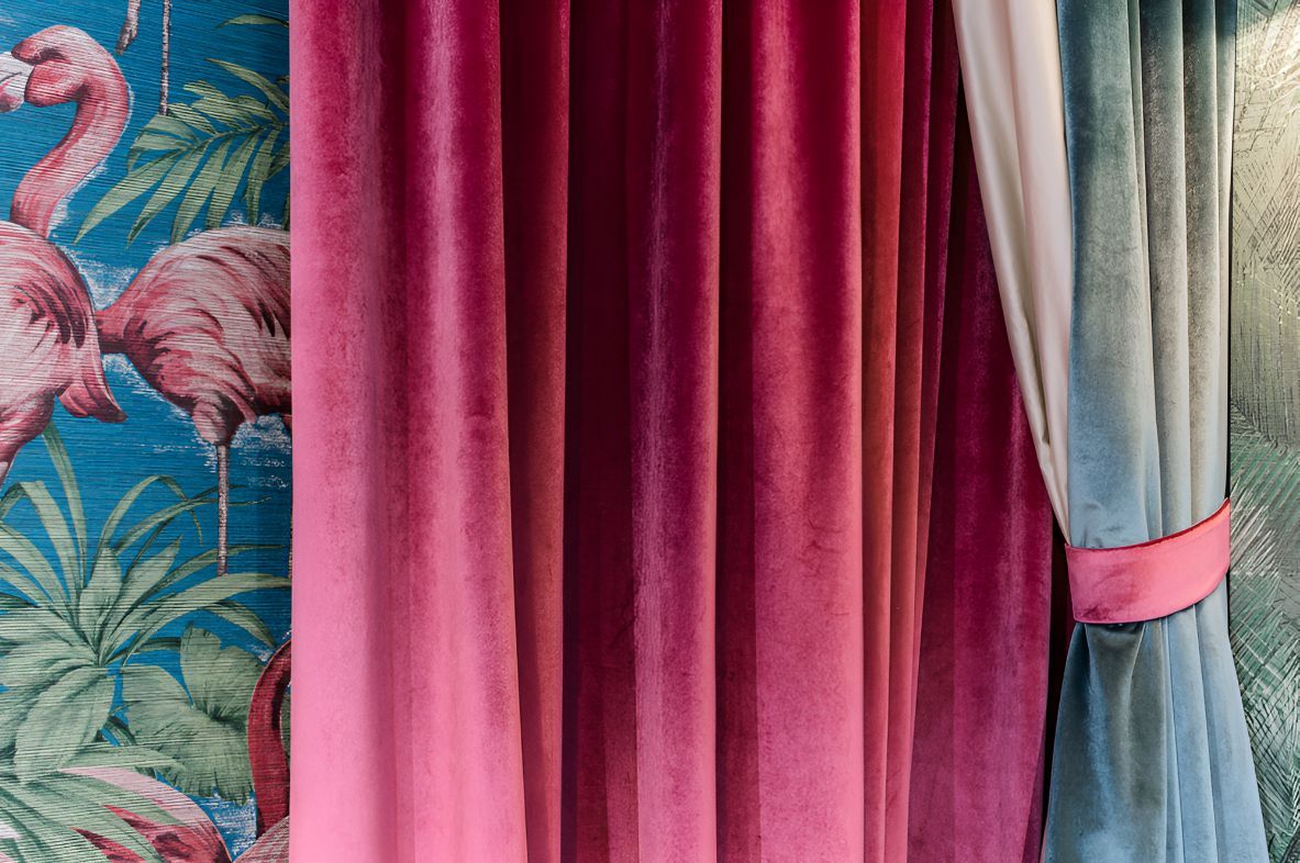 A Close Up of a Pink Velvet Curtain With Flamingos on the Wall Behind It — Newcastle Curtains And Blinds In Warners Bay, NSW