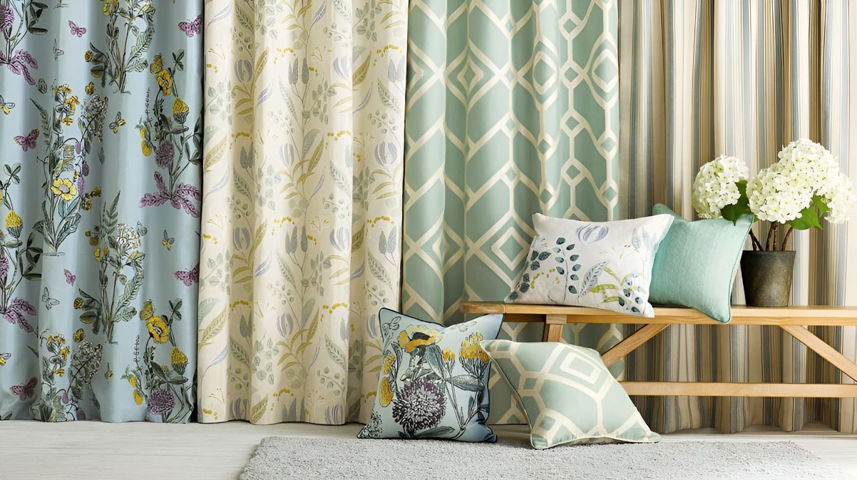A close up of green and cream patterned curtains with flower patterned like pillows — Newcastle Curtains And Blinds In Warners Bay, NSW