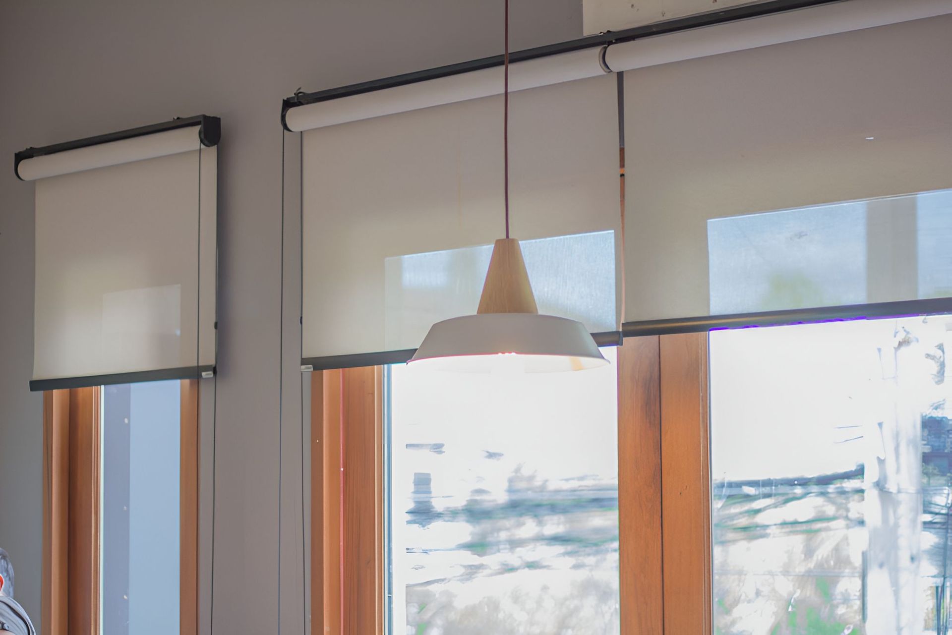 There Are Two Windows With Blinds and a Lamp Hanging From the Ceiling — Newcastle Curtains And Blinds In Wallsend, NSW