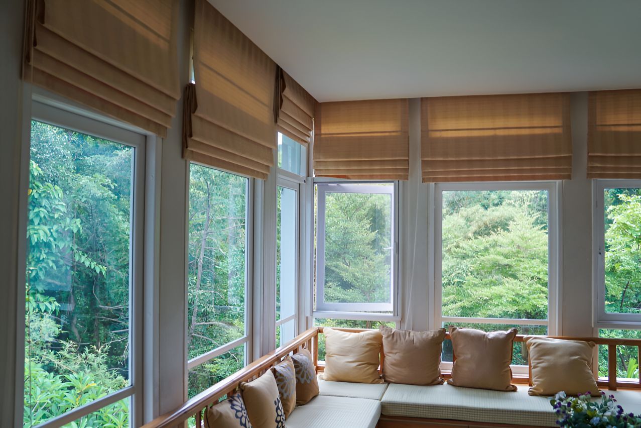 A window sill looking out to bush with cream roller blinds — Newcastle Curtains And Blinds In Warners Bay, NSW