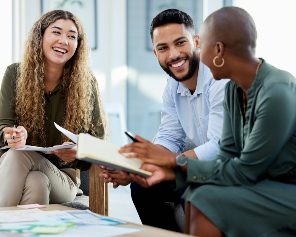 A group of people are sitting around a table having a meeting.