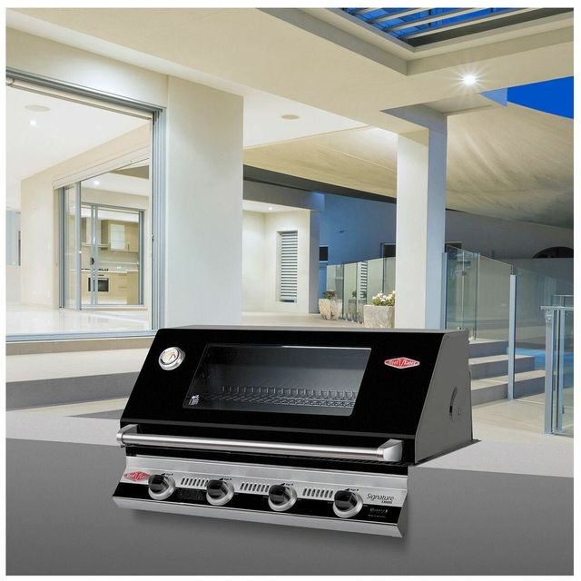 Black built-in gas grill on a modern patio under a covered roof with white columns