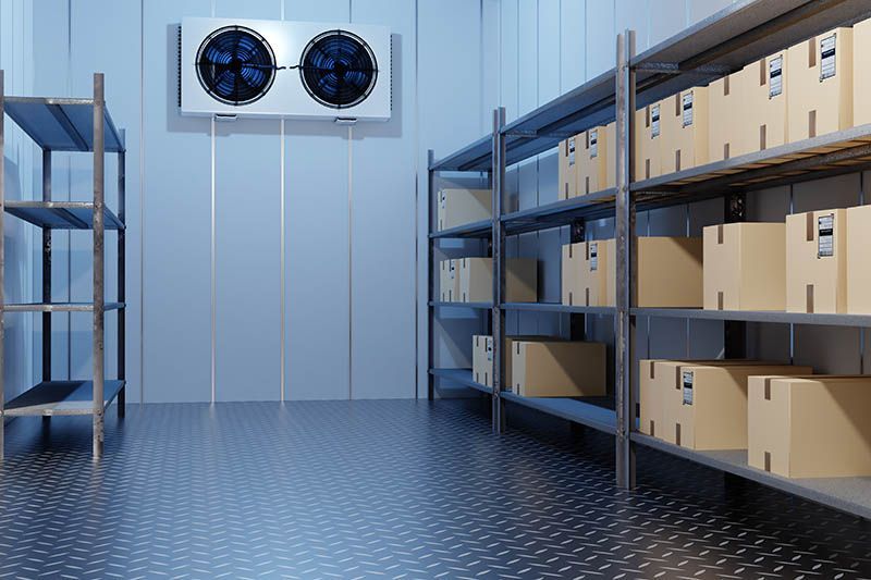 Storage room with metal shelves, cardboard boxes, and a wall-mounted cooling fan