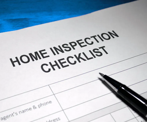 Home inspection checklist form with a black pen on a blue background