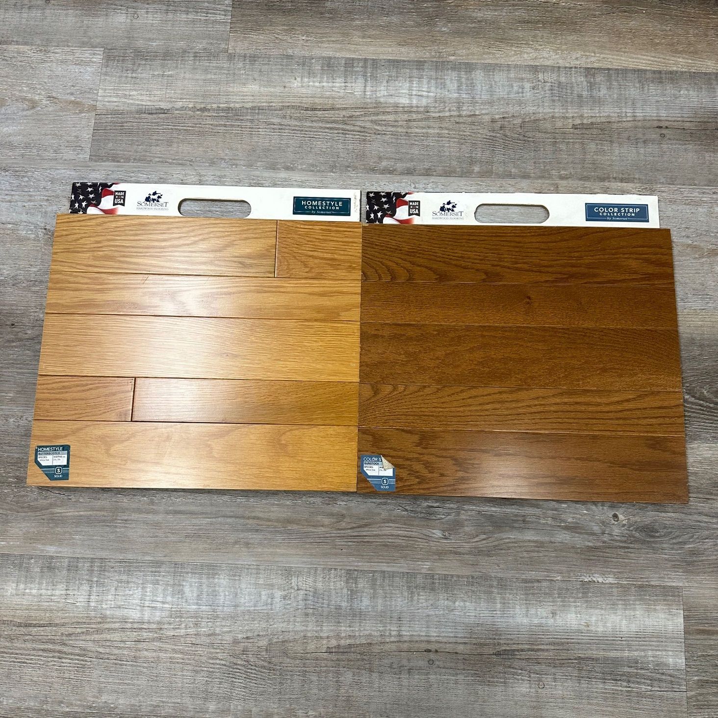 Two wood flooring samples: light brown and dark brown, on a gray floor.