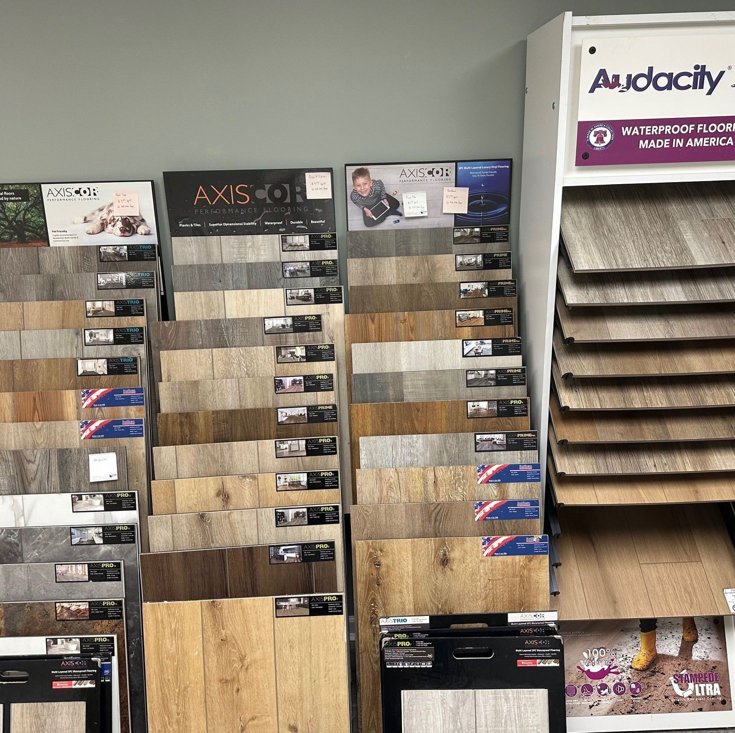 Display of various flooring samples in a showroom, featuring wood-look and stone-look options.