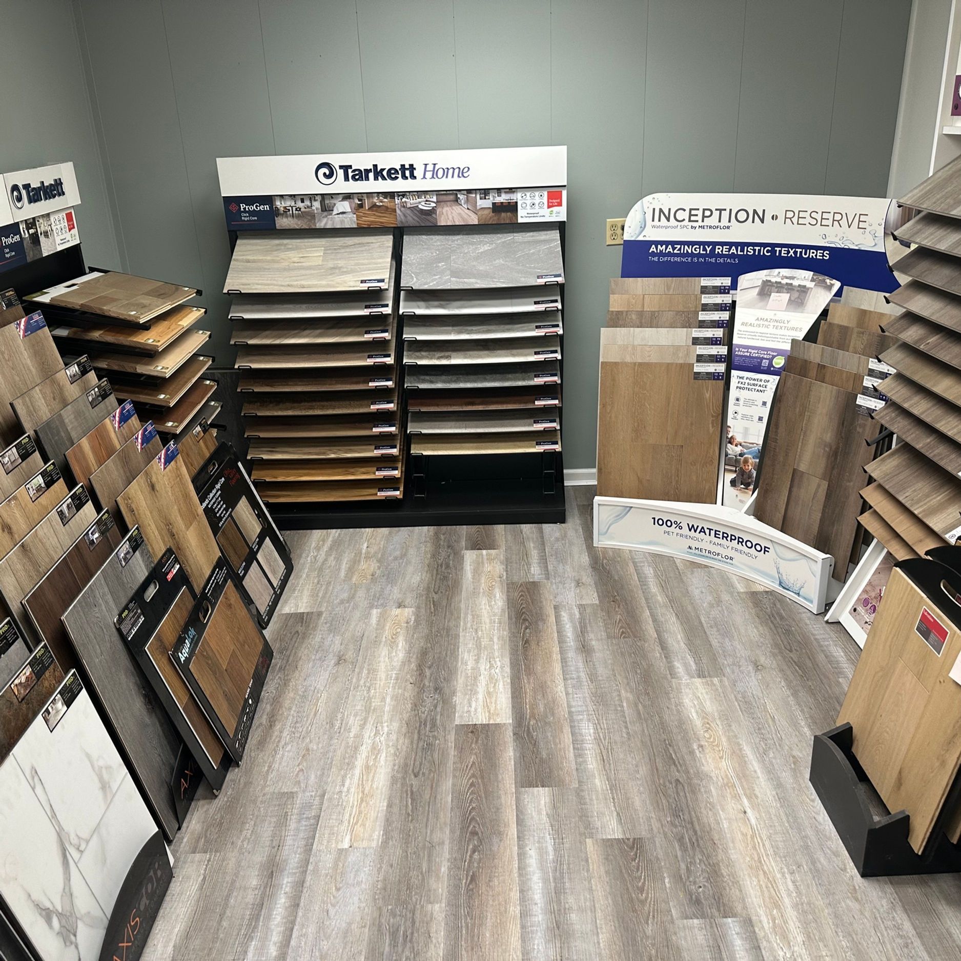 Flooring samples in a showroom, wooden planks on the floor. Display stands of different flooring options.