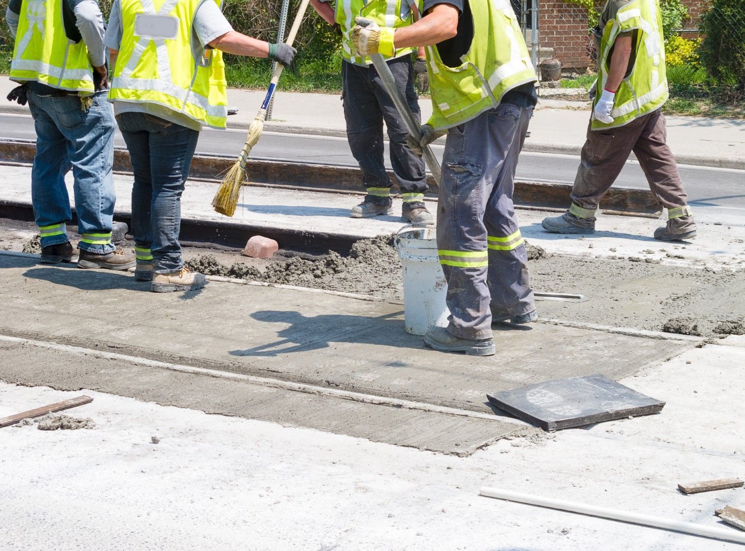 A group of construction workers are working on a sidewalk
